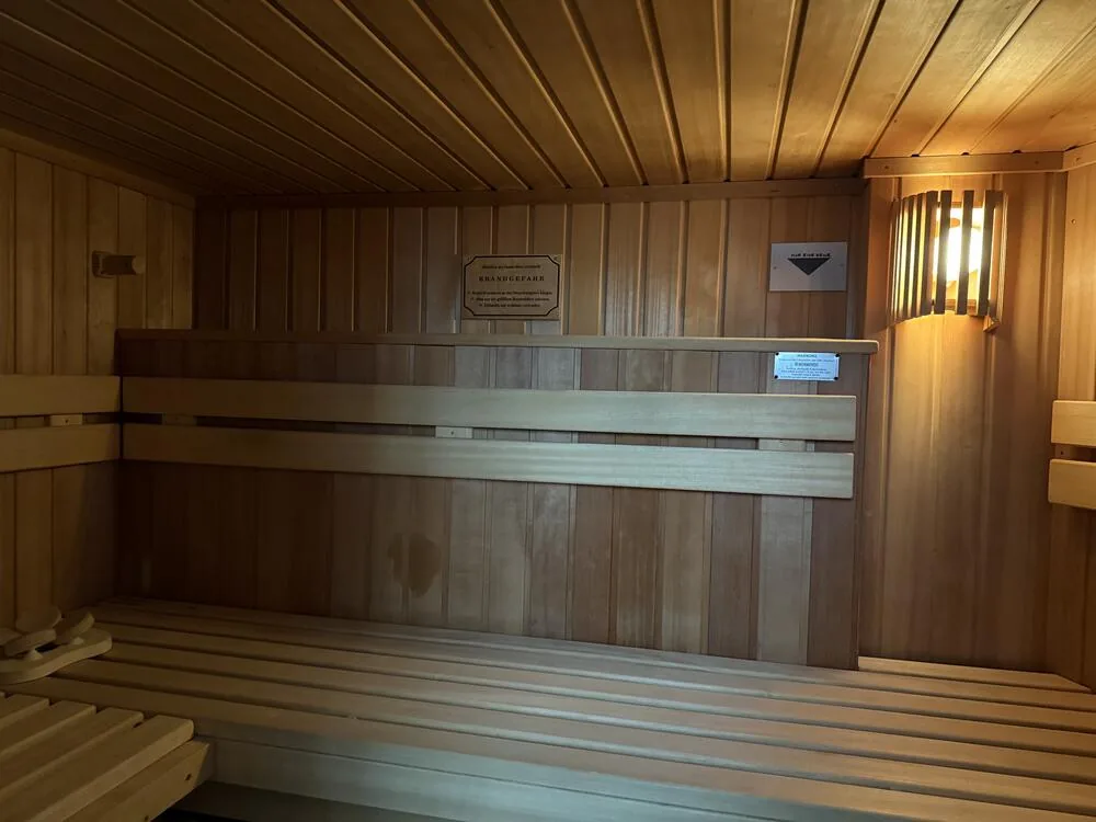 Sauna mit Holzbänken und Wandleuchte